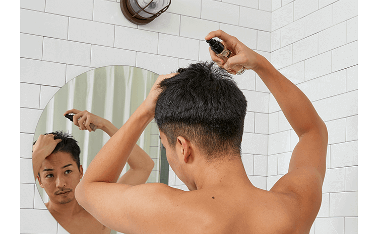 頭皮用美容液で保湿ケアする男性の画像