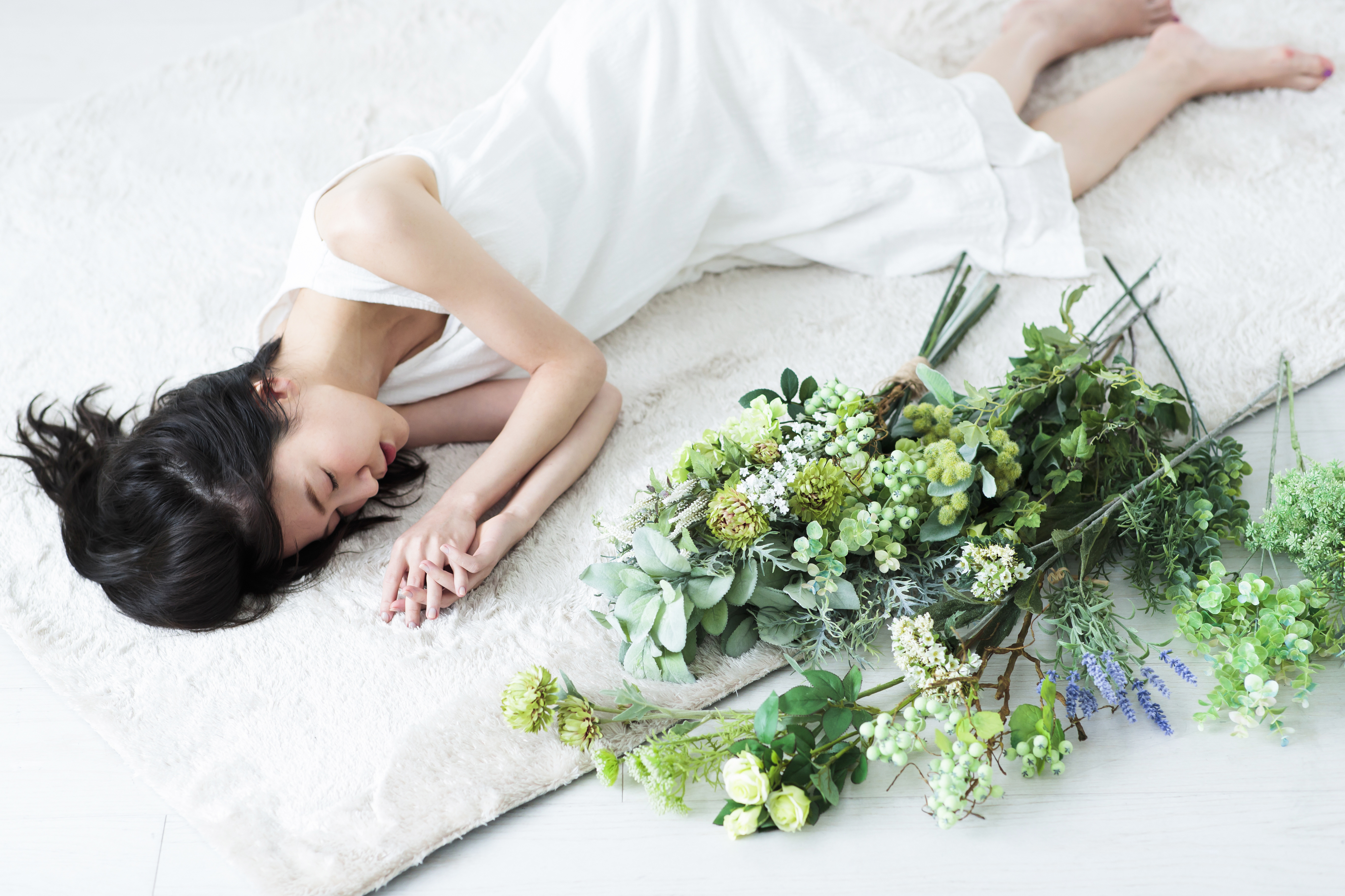 白いワンピースで横たわる女性