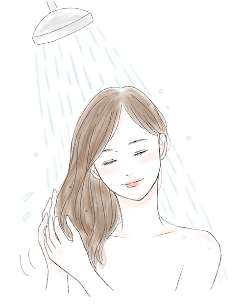 シャワーで髪を洗い流す女性