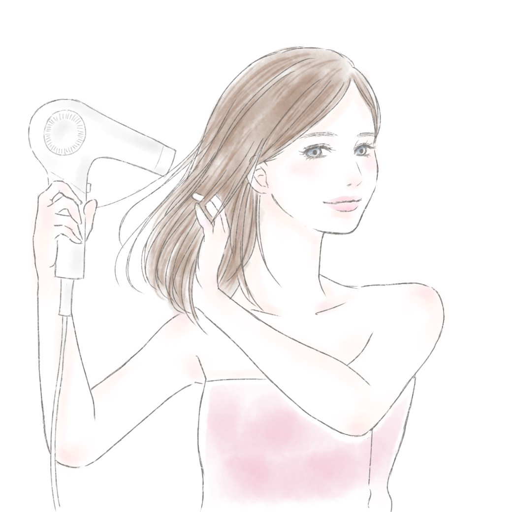 ドライヤーで髪を乾かす女性