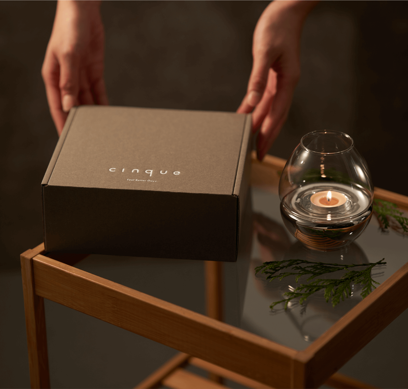 ガラステーブルに置かれたギフトボックスを持つ2つの手