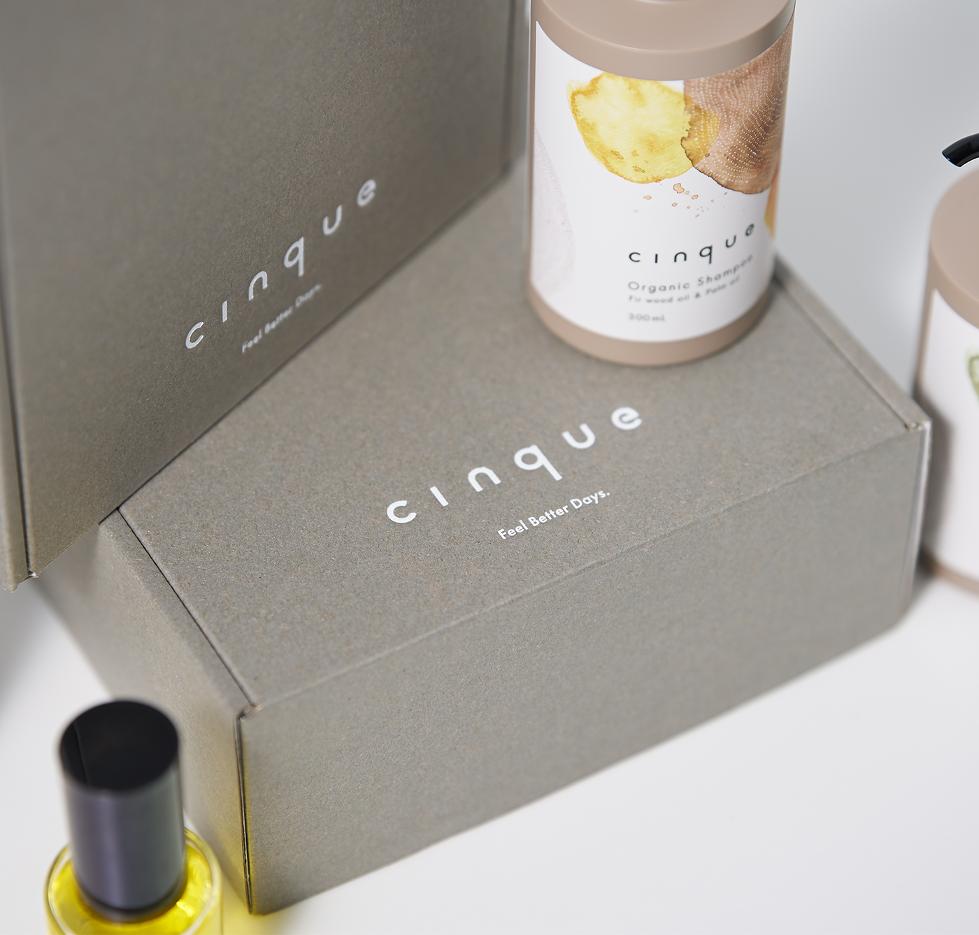 ギフトボックスの上や周りに置かれたシャンプーとヘアオイルのボトル